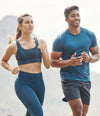 Two people running outdoors with a mountainous background